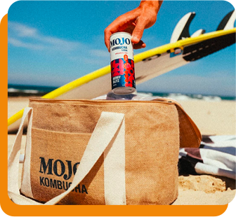 Hand taking a drink can out of a bag at the beach